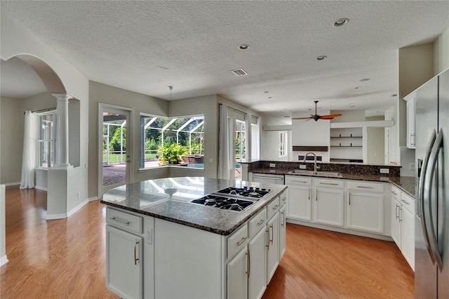 27440 Cedar Park Ct, Wesley Chapel, FL 33544 - kitchen featuring appliances with stainless steel finishes, a sink, arched walkways, a ceiling fan, and white cabinetry