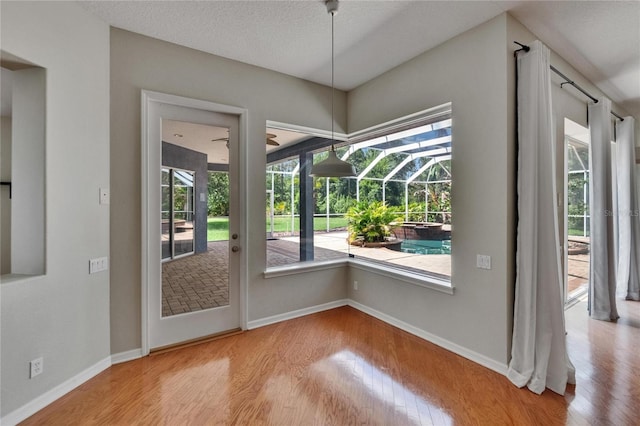 27440 Cedar Park Ct, Wesley Chapel, FL 33544 - doorway to outside featuring a sunroom, wood finished floors, and baseboards