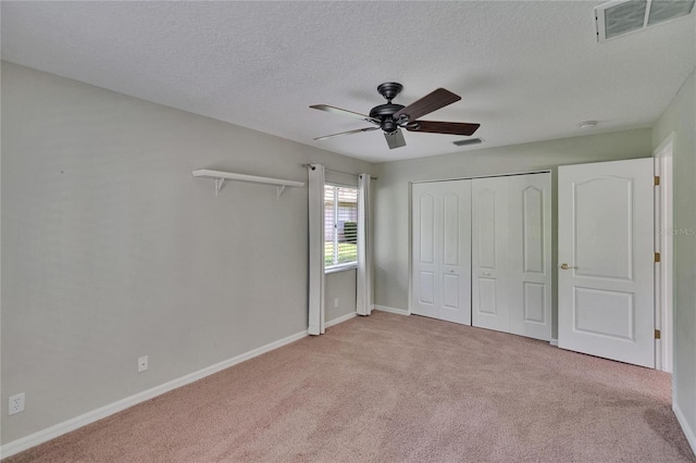 27440 Cedar Park Ct, Wesley Chapel, FL 33544 - unfurnished bedroom with light carpet, a textured ceiling, baseboards, a ceiling fan, and a closet
