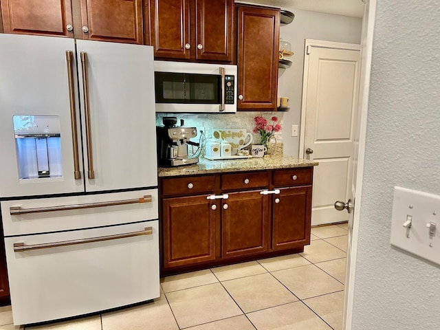 14015 Arbor Pines Dr, Riverview, FL 33579 - kitchen with white refrigerator with ice dispenser, stainless steel microwave, light tile patterned floors, light stone countertops, and open shelves