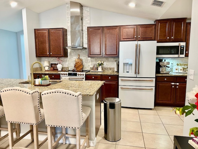 14015 Arbor Pines Dr, Riverview, FL 33579 - kitchen with white fridge with ice dispenser, stainless steel microwave, wall chimney exhaust hood, range, and lofted ceiling