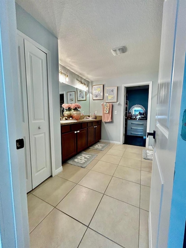 14015 Arbor Pines Dr, Riverview, FL 33579 - bathroom featuring vanity, tile patterned floors, a textured ceiling, baseboards, and a closet