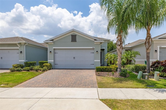 1890 Flora Pass Pl, Kissimmee, FL 34747 - ranch-style home with decorative driveway, stucco siding, a front lawn, and a garage