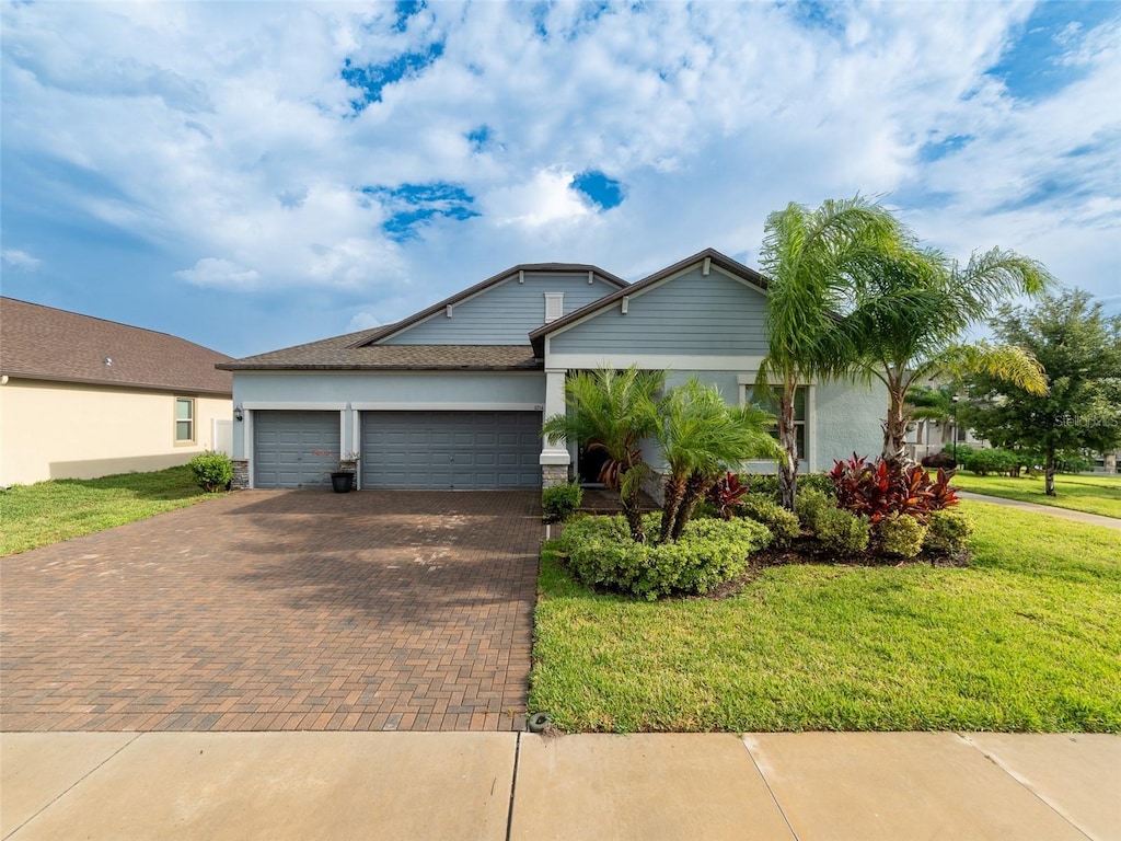 11714 Sunburst Marble Rd, Riverview, FL 33579 - ranch-style home with decorative driveway, a garage, a front yard, and stucco siding