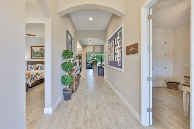 6016 Shadowlake Dr, Apollo Beach, FL 33572 - hallway with arched walkways, light wood finished floors, baseboards, and recessed lighting