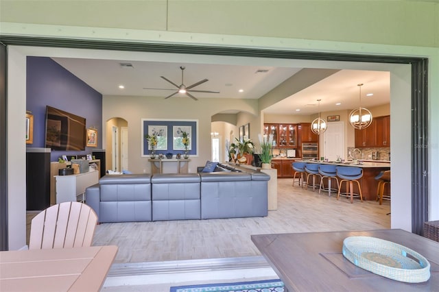 6016 Shadowlake Dr, Apollo Beach, FL 33572 - living area with arched walkways, light wood-style flooring, recessed lighting, and a ceiling fan
