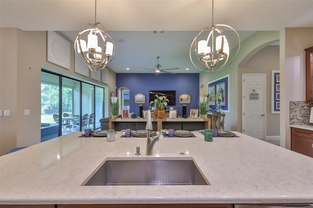 6016 Shadowlake Dr, Apollo Beach, FL 33572 - kitchen with a chandelier, open floor plan, arched walkways, a sink, and recessed lighting