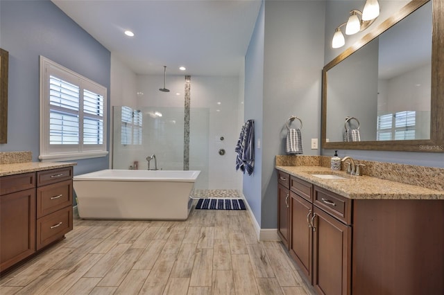 6016 Shadowlake Dr, Apollo Beach, FL 33572 - bathroom with wood finished floors, walk in shower, vanity, a soaking tub, and recessed lighting