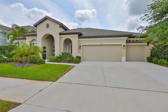 6016 Shadowlake Dr, Apollo Beach, FL 33572 - mediterranean / spanish-style house featuring stucco siding, a garage, driveway, and a front yard