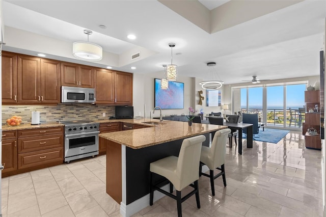 1325 Snell Isle Blvd NE Unit 708, Saint Petersburg, FL 33704 - kitchen featuring stainless steel appliances, light marble finish flooring, brown cabinets, and tasteful backsplash