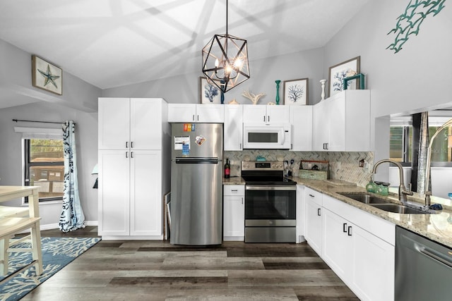 7741 Forest Trl Unit 6, Port Richey, FL 34668 - kitchen featuring stainless steel appliances, a sink, light stone countertops, white cabinetry, and lofted ceiling