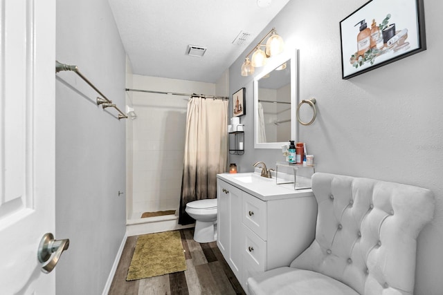 7741 Forest Trl Unit 6, Port Richey, FL 34668 - bathroom featuring toilet, wood finished floors, vanity, tiled shower, and baseboards