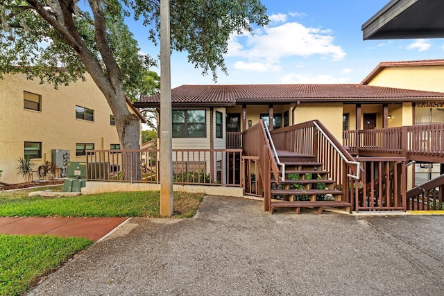 7741 Forest Trl Unit 6, Port Richey, FL 34668 - view of front of house featuring stairs, a tiled roof, and stucco siding