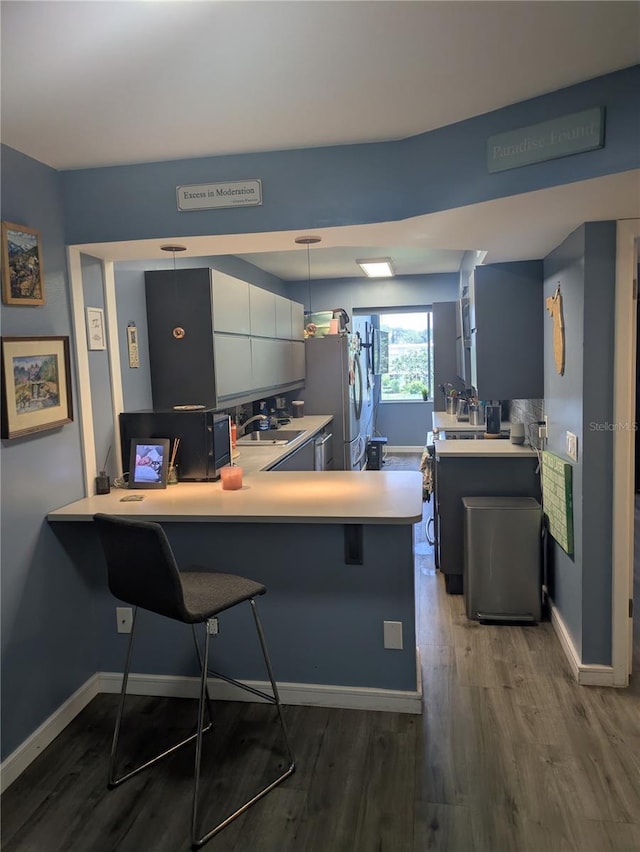 4705 NE 1st St NE Unit 327, Saint Petersburg, FL 33703 - kitchen featuring light countertops, dark wood-style flooring, a peninsula, and freestanding refrigerator