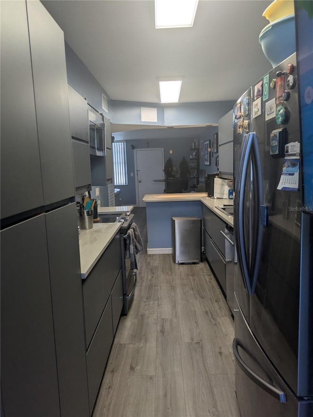 4705 NE 1st St NE Unit 327, Saint Petersburg, FL 33703 - kitchen featuring appliances with stainless steel finishes, light wood-type flooring, light countertops, and gray cabinetry