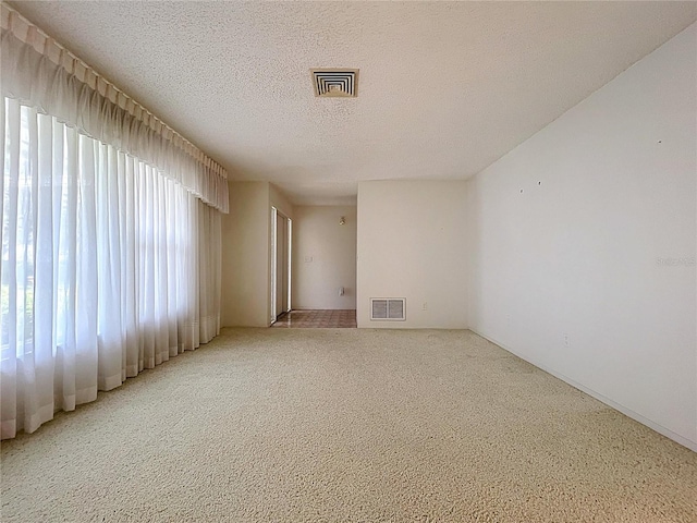 13725 Oak Forest Blvd N, Seminole, FL 33776 - empty room featuring light colored carpet and a textured ceiling