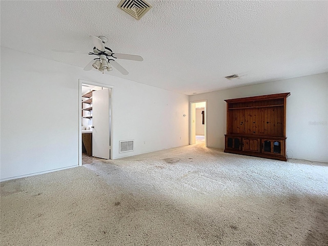 13725 Oak Forest Blvd N, Seminole, FL 33776 - unfurnished living room with a ceiling fan, carpet floors, and a textured ceiling