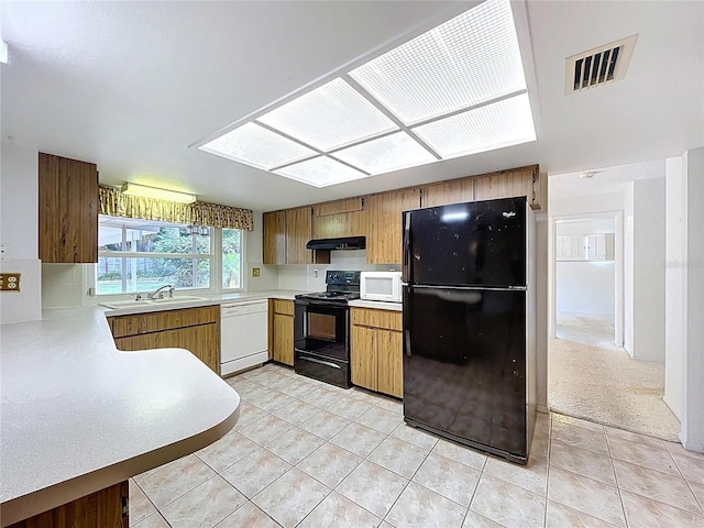 13725 Oak Forest Blvd N, Seminole, FL 33776 - kitchen with black appliances, a sink, light countertops, under cabinet range hood, and light tile patterned flooring