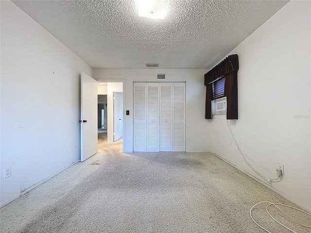13725 Oak Forest Blvd N, Seminole, FL 33776 - unfurnished bedroom featuring a closet, a textured ceiling, cooling unit, and carpet