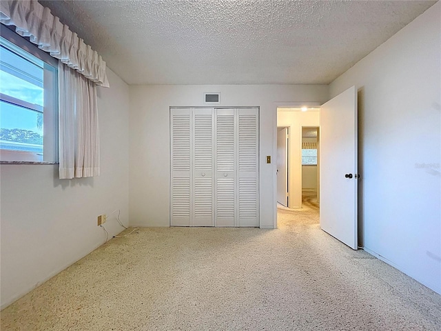 13725 Oak Forest Blvd N, Seminole, FL 33776 - unfurnished bedroom featuring a closet and a textured ceiling