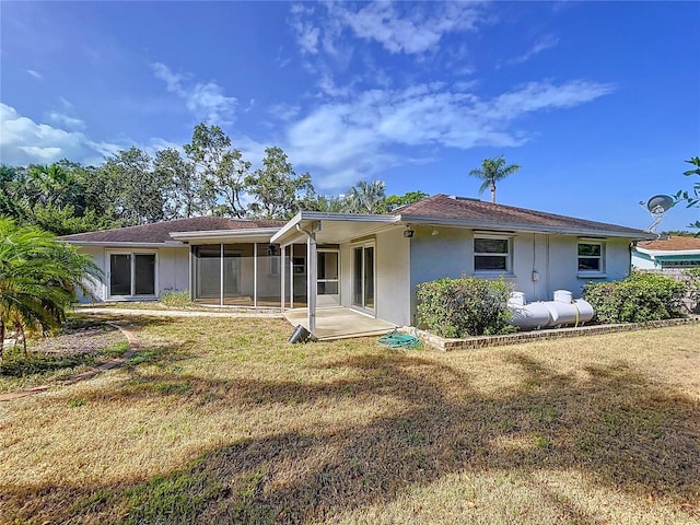 13725 Oak Forest Blvd N, Seminole, FL 33776 - rear view of property featuring stucco siding and a yard