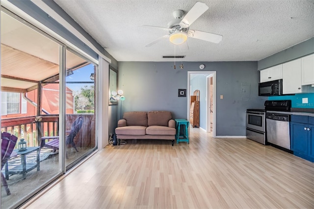 8220 12th Way N Unit G, Saint Petersburg, FL 33702 - living area with light wood-style flooring, a textured ceiling, a ceiling fan, and baseboards