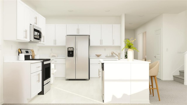 1712 Tropical Oasis Ave, Plant City, FL 33565 - kitchen featuring appliances with stainless steel finishes, white cabinetry, a center island with sink, and light countertops