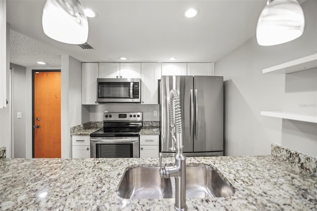 2581 Countryside Blvd Unit 2309, Clearwater, FL 33761 - kitchen with appliances with stainless steel finishes, white cabinetry, light stone counters, and recessed lighting