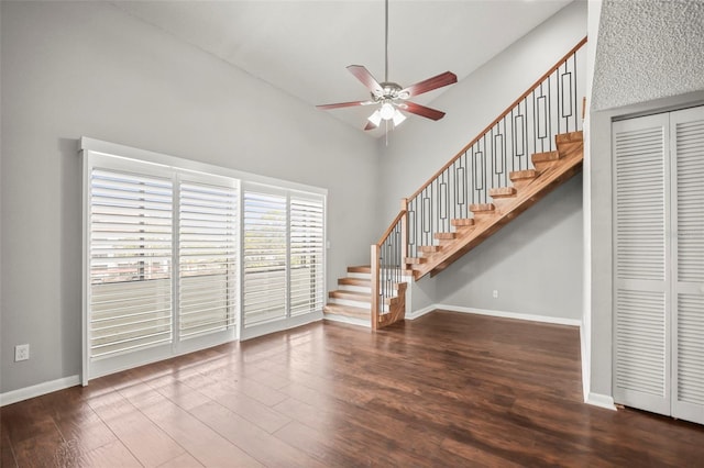 2581 Countryside Blvd Unit 2309, Clearwater, FL 33761 - unfurnished living room featuring ceiling fan, wood finished floors, stairway, a high ceiling, and baseboards