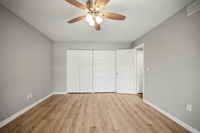 2581 Countryside Blvd Unit 2309, Clearwater, FL 33761 - unfurnished bedroom with light wood-style floors, baseboards, a textured ceiling, a closet, and ceiling fan