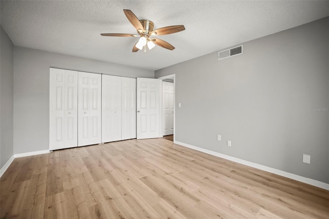2581 Countryside Blvd Unit 2309, Clearwater, FL 33761 - unfurnished bedroom with baseboards, light wood-type flooring, a textured ceiling, a closet, and ceiling fan