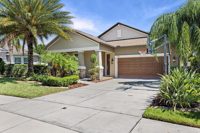 32193 Watoga Loop, Wesley Chapel, FL 33543 - view of front facade with an attached garage, stucco siding, concrete driveway, and a porch