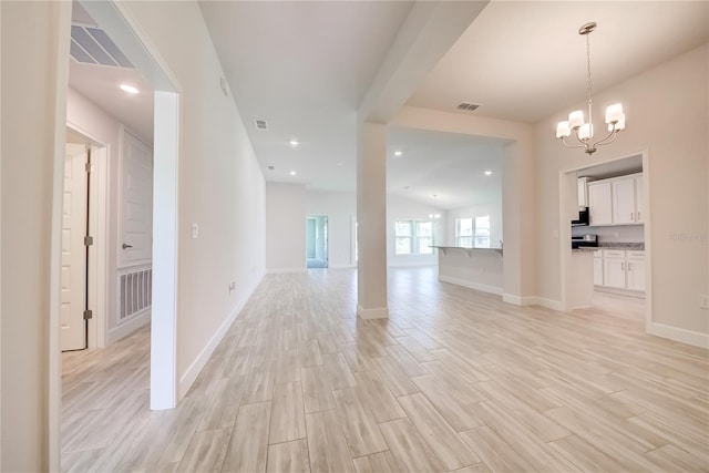 16508 66th Ln E, Parrish, FL 34219 - empty room with light wood finished floors, a chandelier, and baseboards