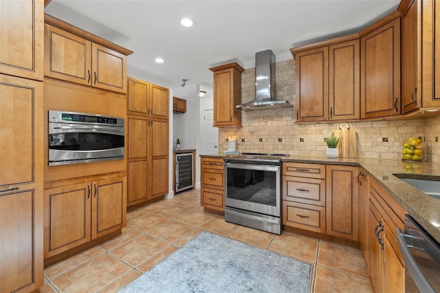 715 45th Ave NE, Saint Petersburg, FL 33703 - kitchen with stainless steel appliances, wall chimney exhaust hood, beverage cooler, brown cabinetry, and decorative backsplash