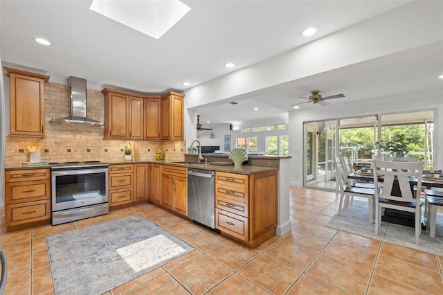 715 45th Ave NE, Saint Petersburg, FL 33703 - kitchen with wall chimney range hood, appliances with stainless steel finishes, a peninsula, decorative backsplash, and light tile patterned flooring