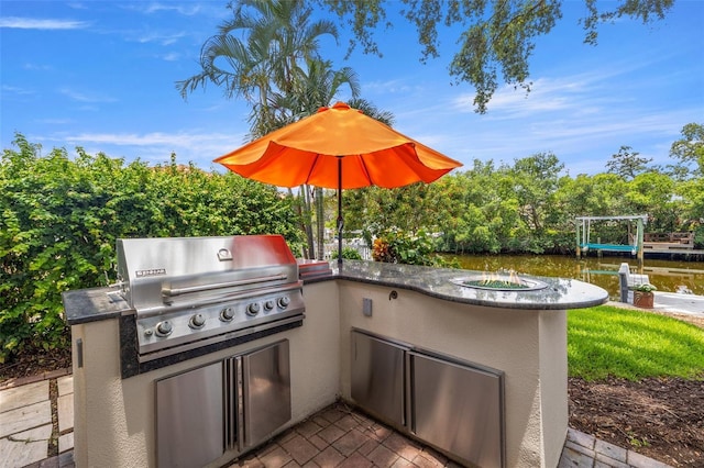 715 45th Ave NE, Saint Petersburg, FL 33703 - view of patio / terrace with an outdoor kitchen, view of wooded area, and a water view