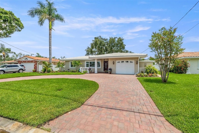 715 45th Ave NE, Saint Petersburg, FL 33703 - ranch-style house featuring decorative driveway, an attached garage, stucco siding, a front yard, and a tile roof