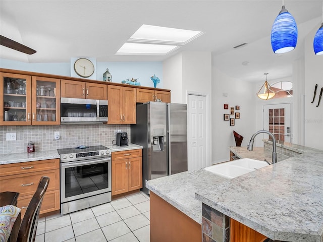 1102 Goshen Rd, Tarpon Springs, FL 34689 - kitchen featuring stainless steel appliances, a sink, brown cabinets, and vaulted ceiling