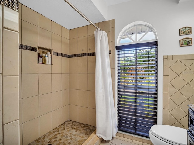 1102 Goshen Rd, Tarpon Springs, FL 34689 - bathroom featuring toilet, a tile shower, tile patterned floors, and tile walls
