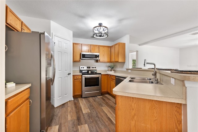 9700 SW 196th Cir, Dunnellon, FL 34432 - kitchen with appliances with stainless steel finishes, a sink, dark wood-type flooring, light countertops, and a peninsula