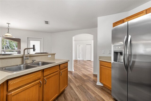 9700 SW 196th Cir, Dunnellon, FL 34432 - kitchen featuring stainless steel refrigerator with ice dispenser, a sink, arched walkways, dark wood finished floors, and light countertops