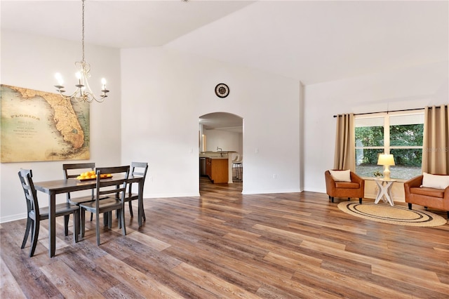 9700 SW 196th Cir, Dunnellon, FL 34432 - dining room featuring arched walkways, wood finished floors, high vaulted ceiling, a chandelier, and baseboards