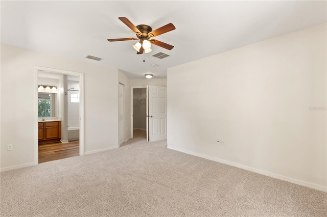 9700 SW 196th Cir, Dunnellon, FL 34432 - unfurnished bedroom with light carpet, baseboards, ensuite bathroom, and a ceiling fan