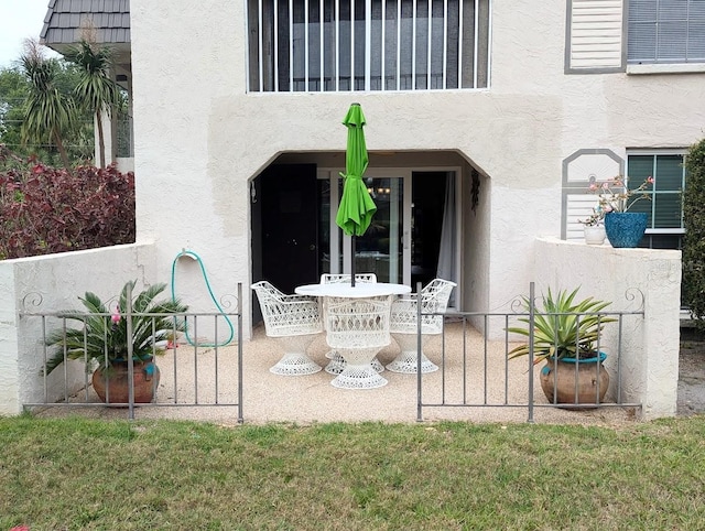 8765 Bardmoor Blvd Unit 108, Seminole, FL 33777 - view of exterior entry with stucco siding and a patio area