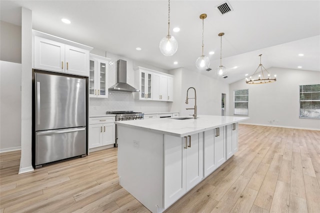 9402 Woodbay Dr, Tampa, FL 33626 - kitchen featuring appliances with stainless steel finishes, wall chimney range hood, a sink, white cabinetry, and recessed lighting