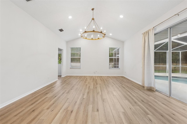 9402 Woodbay Dr, Tampa, FL 33626 - unfurnished room with healthy amount of natural light, a chandelier, light wood-style floors, vaulted ceiling, and baseboards