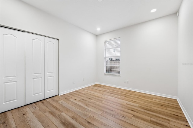 9402 Woodbay Dr, Tampa, FL 33626 - unfurnished bedroom featuring light wood-type flooring, baseboards, a closet, and recessed lighting