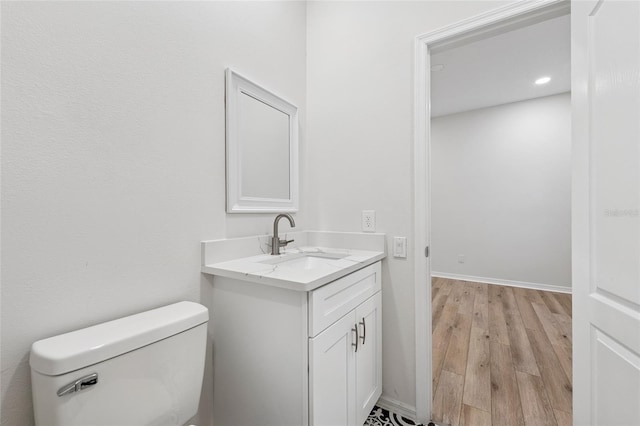 9402 Woodbay Dr, Tampa, FL 33626 - bathroom with vanity, wood finished floors, toilet, recessed lighting, and baseboards