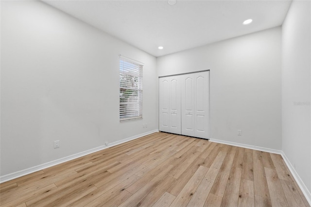 9402 Woodbay Dr, Tampa, FL 33626 - unfurnished bedroom featuring light wood-type flooring, baseboards, recessed lighting, and a closet