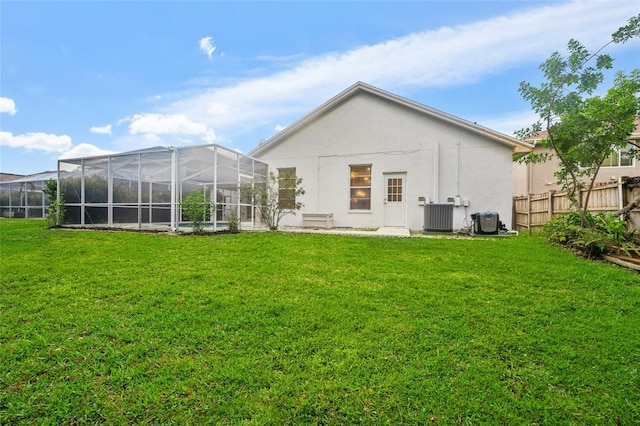9402 Woodbay Dr, Tampa, FL 33626 - back of property with stucco siding, central air condition unit, and glass enclosure